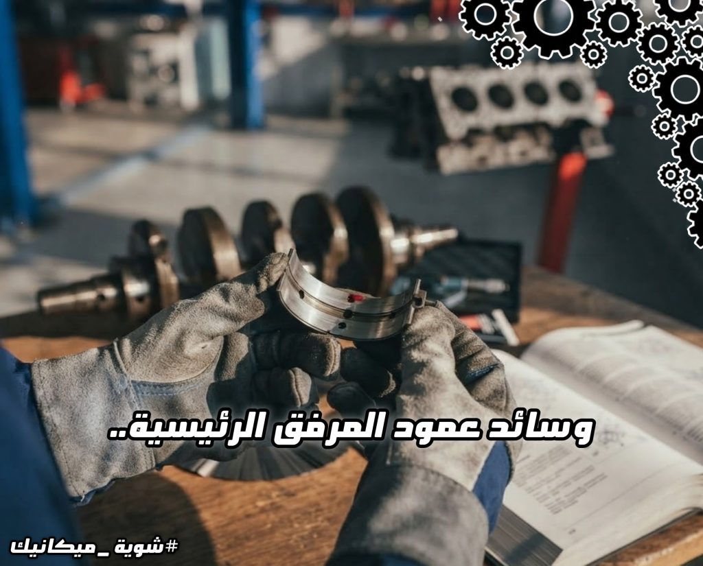 كتلة محرك سيارة مثبتة على حامل التجميع في الورشة مع عبارة "وسائد عمود المرفق الرئيسية.. الكوسيني" في واجهة الصورة